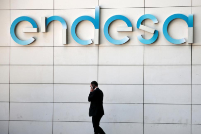 n hombre camina bajo el logo de Endesa en la sede de la empresa en Madrid-REUTERS