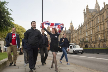 Partidarios de abandonar la UE celebran el resultado del referéndum mientras pasan frente al Parlamento, en Londres.-AP / ANTHONY DEVLIN