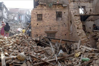 Residentes en Bhaktapur buscan pertenencias entre sus hogares arrasados por el seísmo, este lunes.-Foto:   REUTERS / ATHIT PERAWONGMETHA