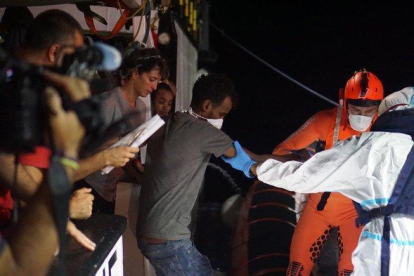 Efectivos de la Guardia Costera proceden a la evacuación de 8 personas necesitadas de asistencia urgente que permanecían en el barco de la ONG española Open Arms, que sigue bloqueado desde hace 18 días frente a la isla italiana de Lampedusa.-EFE