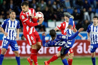 El delantero uruguayo del Alavés Diego Rolan remata ante el centrocampista del Girona Alex Granell.-