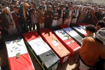 Yemenís rezan frente a las lapidas de las victimas de un bombardeo de la coalicion arabe comandada por Arabia Saudi  durante un funeral en Sana.-/ YAHYA ARHAB / EFE