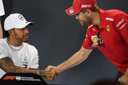 Sebatian Vettel (Ferrari), a la derecha, saluda a Lewis Hamilton (Mercedes), en el inicio de la conferencia de prensa de presentación del GP de Australia.-AFP / WILLIAM WEST