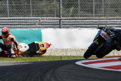Marc Márquez (Honda) se ha caído hoy en la última curva de Sepang, justo delante del australiano Jac Miller (Honda).-AFP / MOHD RASFAN