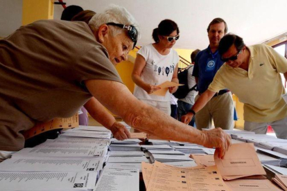 Votantes eligen papeletas en un colegio electoral de Madrid en las elecciones generales del 26 de junio de 2016.-JUAN MANUEL PRATS