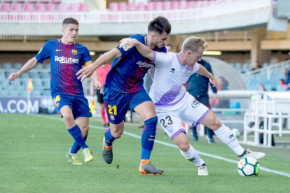 Dani Nieto protege el balón ante Costas durante el partido disputado ayer en Barcelona.-AREA 11