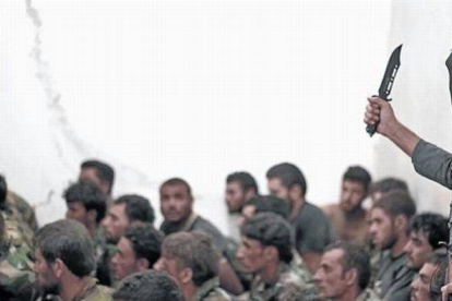 Combatiente del Estado Islámico junto a soldados sirios, tras la toma de una base cerca de Raqqa.-Foto: AP