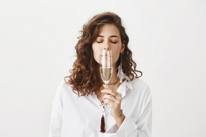 Una mujer enferma trata de oler una copa de vino. / EL MUNDO