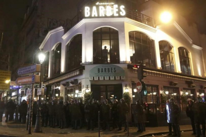 Policías antidisturbios frenta a una 'brasserie' durante la protesta contra la brutalidad policial, este miércoles, en París.-CHRISTIAN HARTMANN