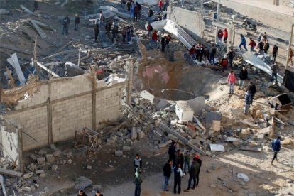 Varios palestinos observan los destrozos del bombardeo israelí de este sábado en Gaza.-REUTERS / MOHAMMED SALEM