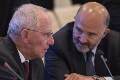 El ministro de Finanzas alemán, Wolfgang Schauble, conversa con el comisario europeo de Asuntos Economicos y Financieros, Pierre Moscovici, durante la reunion de los ministros de Economia y Finanzas de la zona de euro en Bratislava.-FILIP SINGER