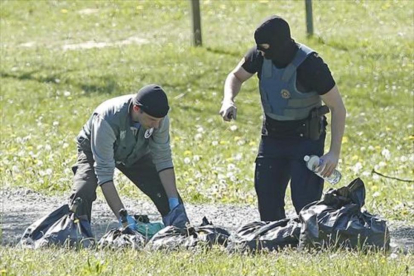 Policías franceses examinan las armas de uno de los zulos de ETA.-GUILLAUME HORCAJUELO