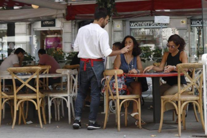 Un camarero trabajando en la Rambla de Cataluña.-EL PERIÓDICO