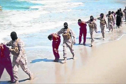Imagen del vídeo del EI con yihadistas encapuchados conduciendo a sus víctimas por una playa de Libia.-Foto: AP