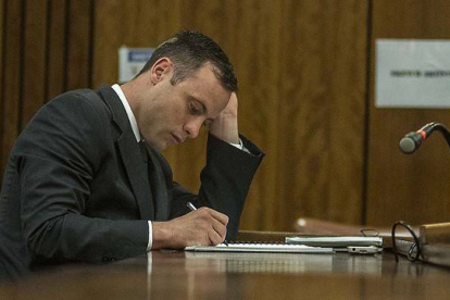 Oscar Pistorius toma notas durante la tercera jornada de la vista para imponer una pena al deportista por un delito de homicidio imprudente.-
