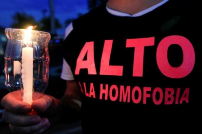 Un activista por los derechos de los homosexuales sostiene una vela encendida en recuerdo de las víctimas de Orlando.-REUTERS / OSWALDO RIVAS