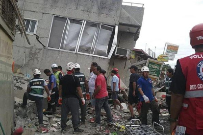 Miembros del servicio de rescate inspeccionan un edificio en Padada Davao afectado por el terremoto en busca de víctimas.-EFE