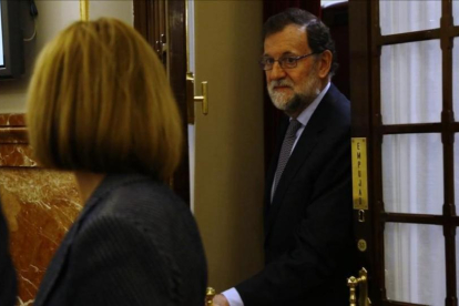 El presidente del Gobierno, Mariano Rajoy, y la ministra de Defensa, María Dolores de Cospedal, en los pasillos del Congreso.-AGUSTÍN CATALÁN