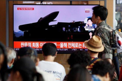 Un grupo de surcoreanos ven este viernes  en la pantalla de un comercio  las ultimas noticias sobre los proyectiles de corto alcance que ha lanzado Corea del Norte desde su costa oriental.-EFE / JEON HEON-KYUN