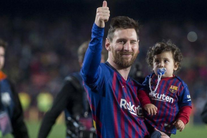 Messi da la vuelta al campo con Ciro, su tercer hijo, en brazos, en la fiesta del alirón tras el triunfo sobre el Levante.-JORDI COTRINA