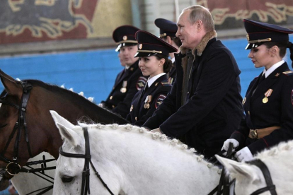 El presidente de Rusia, Vladímir Putin, sobre un caballo junto a agentes de policía de la unidad montada de Moscú, el 7 de marzo del 2019.-REUTERS
