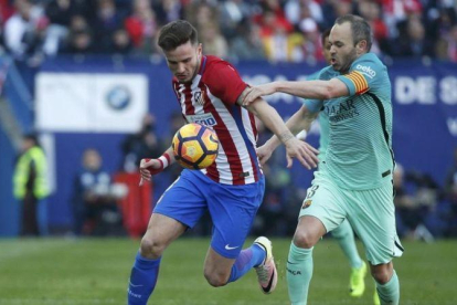 Iniesta pelea por el balón con Saúl, el jugador del Atlético, en el Calderón.-REUTERS / JUAN MEDINA