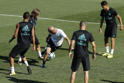 Zidane, en el centro de un rondo durante el entrenamiento de este sábado.-JUAN CARLOS HIDALGO / EFE