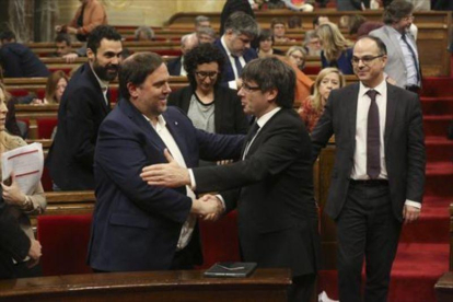 Junqueras y Puigdemont se saludan en el Parlament, en marzo.-DANNY CAMINAL