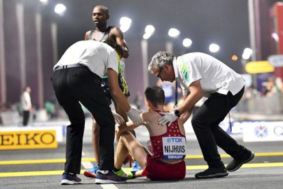 Un participante del maratón necesita ayuda a la conclusión de la prueba en el Mundial de Doha.-EFE / EPA / NOUSHAD THEKKAYIL