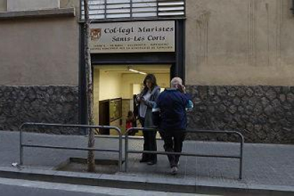 Un hombre borra a las ocho de la mañana las pintadas aparecidas en el colegio de los Maristas de Sants-Les Corts.-JULIO CARBÓ
