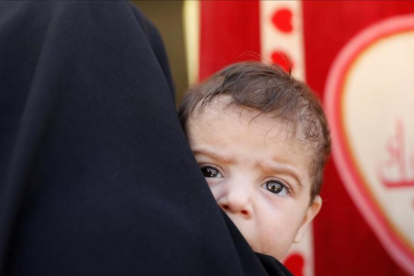 Una mujer con su hijo en brazos en una hospital móvil en el oeste de la ciudad de Mosul.-REUTERS