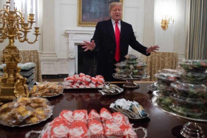 Trump ante las hamburguesas que encargó para recibir a un equipo de fútbol americano.-SAUL LOEB / AFP