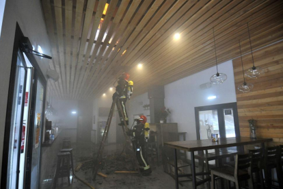 Dos bomberos en las labores de extinción del incendio declarado en el restaurante de Soto Playa.-VALENTIN GUISANDE