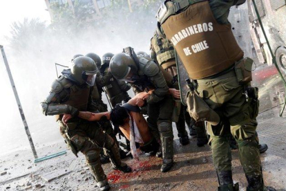 Un herido es trasladado por las fuerzas de seguridad durante las protestas en Santiago.-