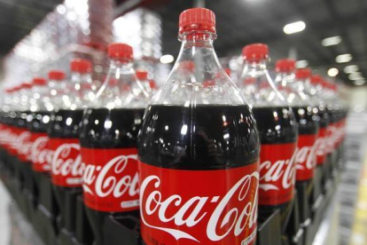 Botellas de Coca-cola en una fábrica preparadas para su distribución.-