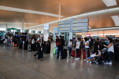Colas de pasajeros esperando para facturar en los mostradores de Vueling en la T-1 del aeropuerto de El Prat.-JOSEP GARCIA