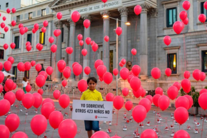 El pequeño Said, de 8 años, sostiene frente al Congreso el cartel en recuerdo de los 423 niños que se han ahogado en el Mediterráneo en el último año.-Pedro Armestre/Save the Children