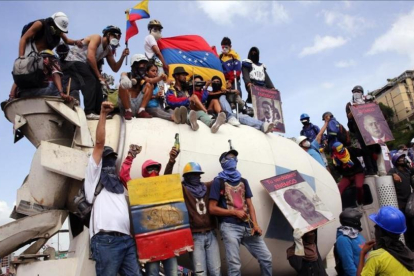 El violinista venezolano Willy Arteaga (arriba)  toca junto a manifestantes sobre una mezcladora de cemento durante una protesta de este pasado sabado en Caracas.-MAURICIO DUEÑAS CASTAÑEDA