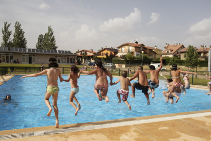 Unos niños saltan a la piscina de Los Rábanos en una imagen de archivo definitoria del verano en Soria.
