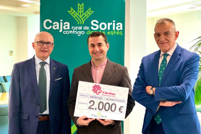 El responsable de Cáritas Soria con el cheque entregado por Caja Rural de Soria.