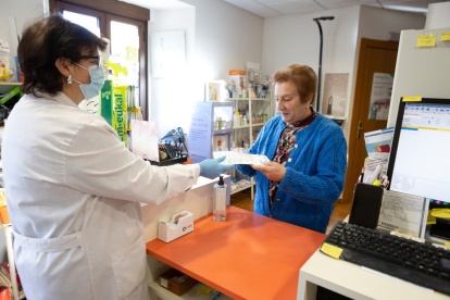 Una usuaria recoge la medicación semanal en la farmacia rural de Valdeavellano de Tera.