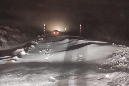 Luces de uno de los vehículos atrapados en la nieve en la carretera de Oncala.