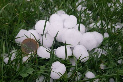 Las bolas de pedrisco de la tormenta comparadas con una moneda de euro.