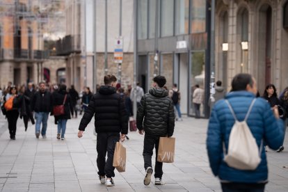 Archivo - Jóvenes sujetan bolsas con compras durante la campaña de Navidad de 2023.