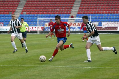 Un jugador rojillo avanza perseguido por un futbolista del equipo cántabro.