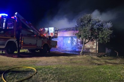 Al fondo, la vivienda y un camión de bomberos durante la extinción.