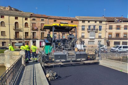 Tareas de asfaltado en el puente medieval