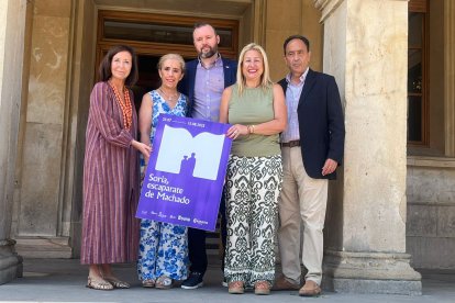 Las autoridades posan con el cartel de la nueva campaña de promoción comercial.