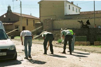 Miembros de la guardia civil recogiendo restos de explosivos con el coche bomba y la casa cuartel al fondo.
soria 16/7/00 atentado de agreda Goyo gonzalo