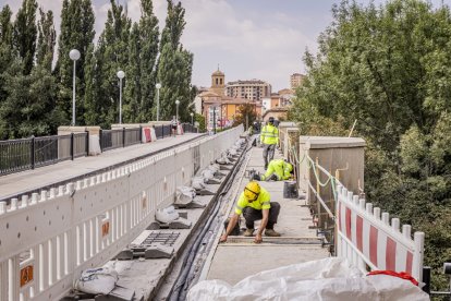Trabajadores en el puente de piedra de Soria en la mañana de este miércoles.